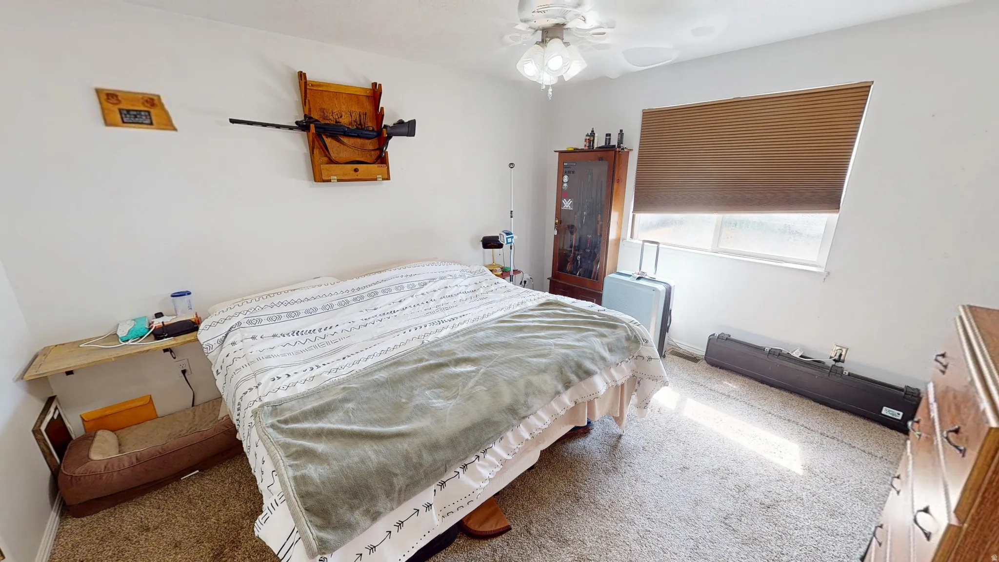 Carpeted room featuring a ceiling fan, a window with blinds, and white walls