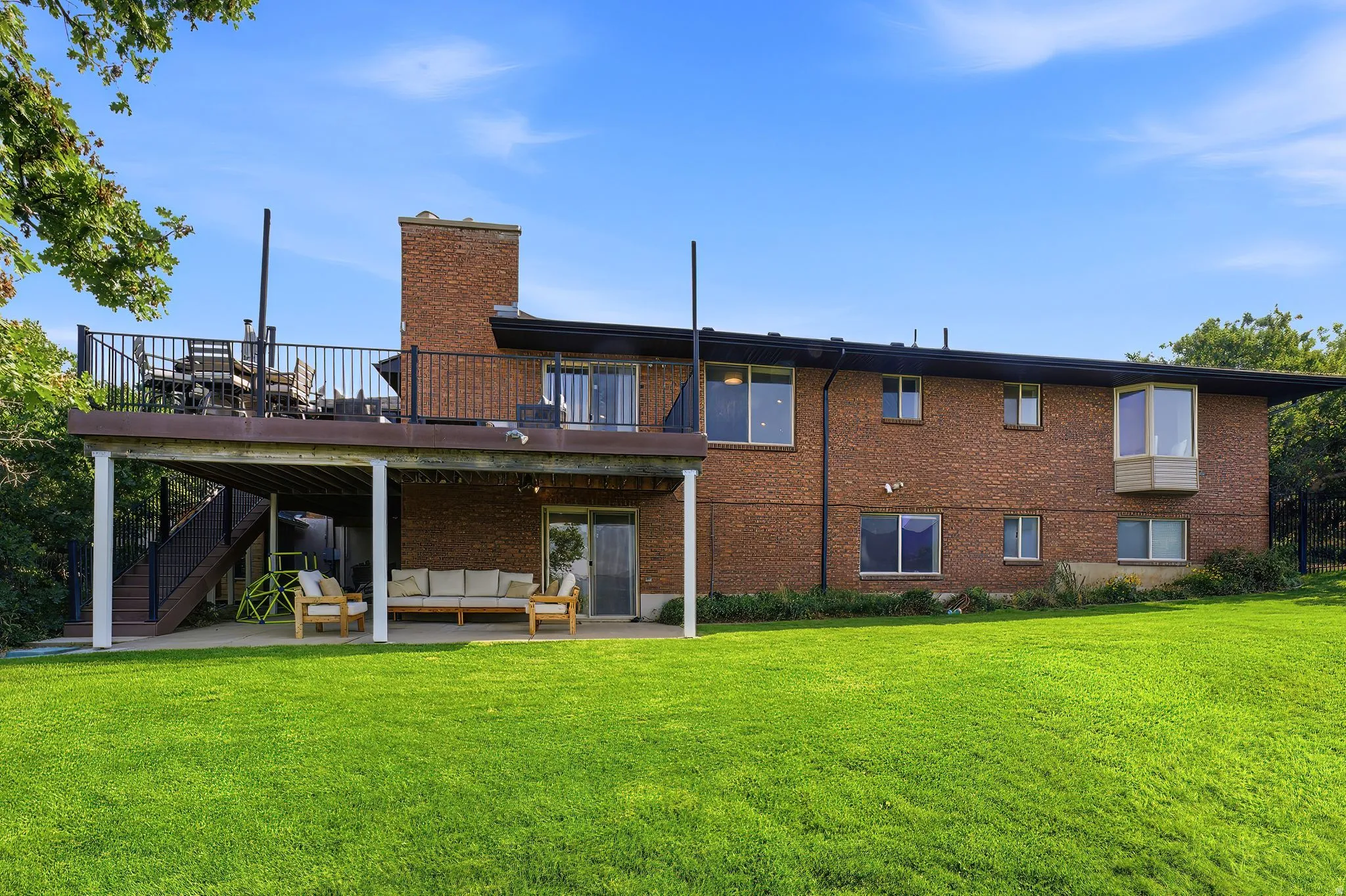 Brick exterior featuring a multi-level deck and patio