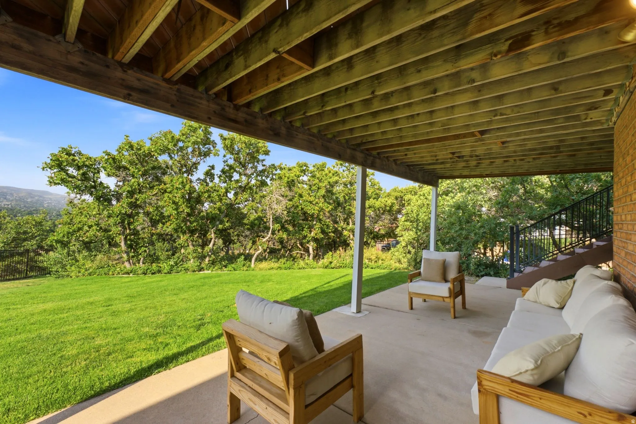 Spacious concrete patio featuring an exposed wood beam ceiling