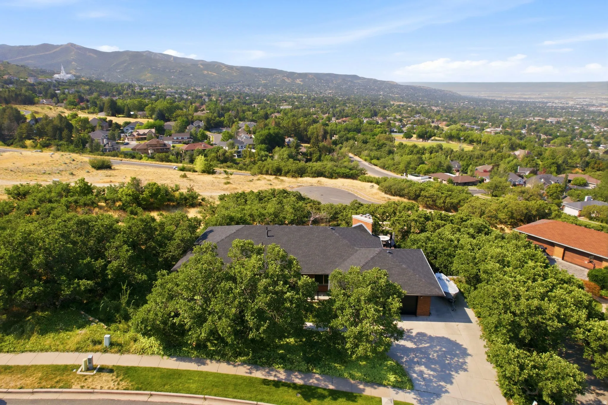 Property situated on a verdant hillside with mature trees