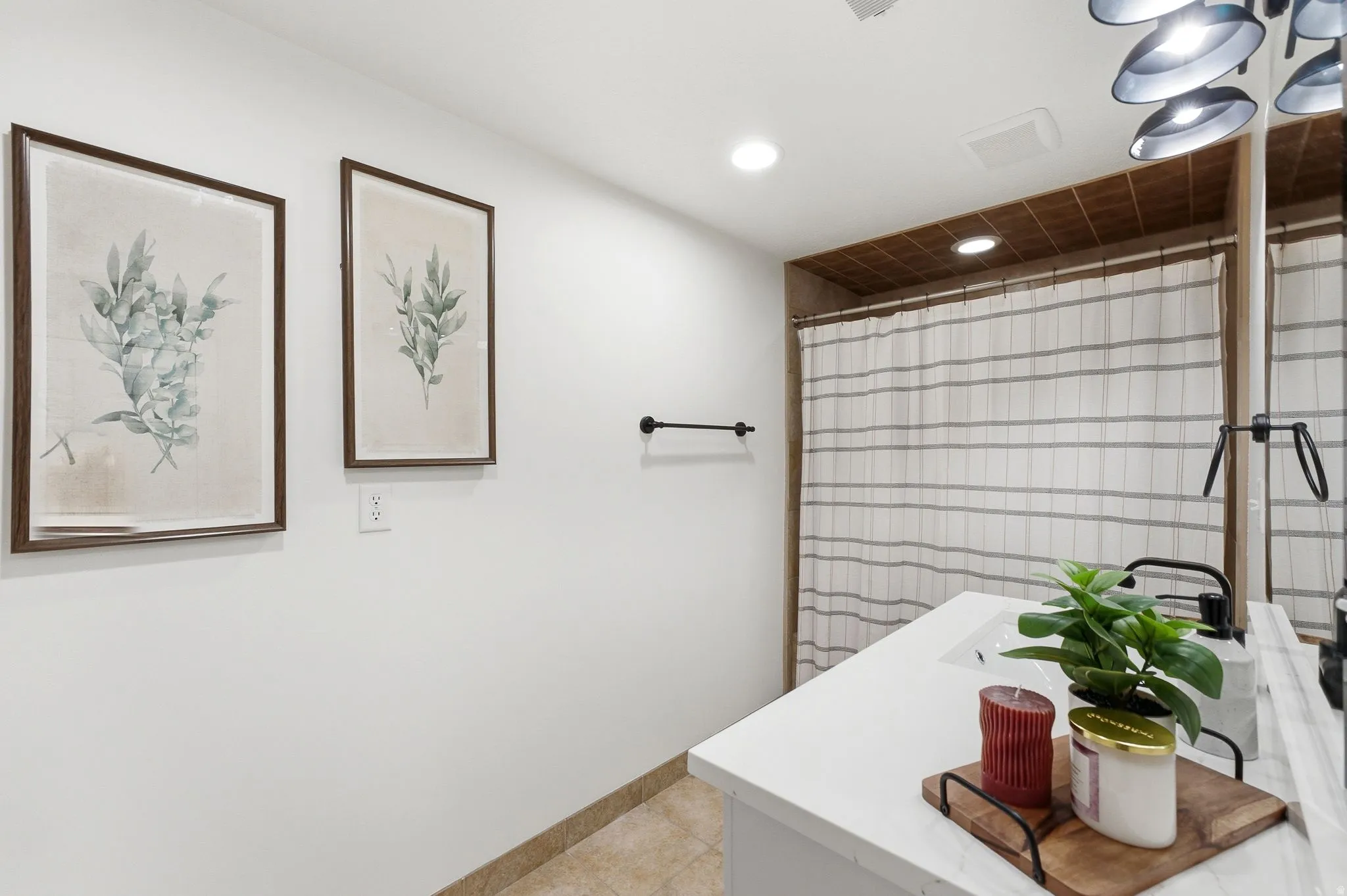 Bathroom featuring a white vanity with an integrated sink, black faucet, and a shower with a striped curtain
