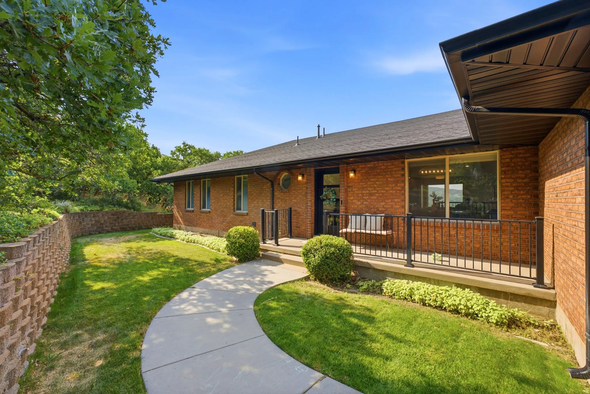 Brick exterior with a dark shingle roof and black gutters