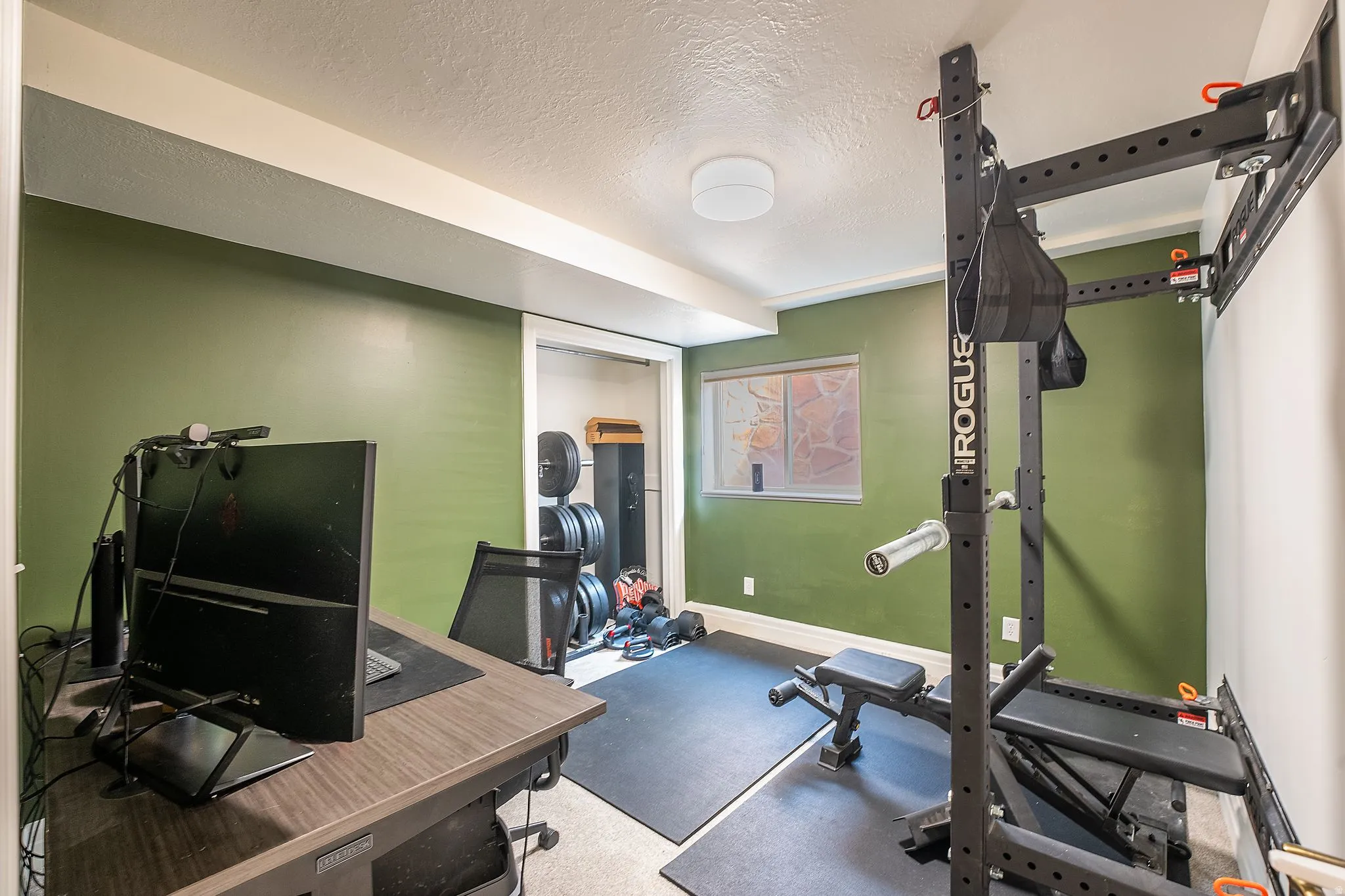 Dedicated room featuring a dark wood-finish desk, recessed window, and green accent walls