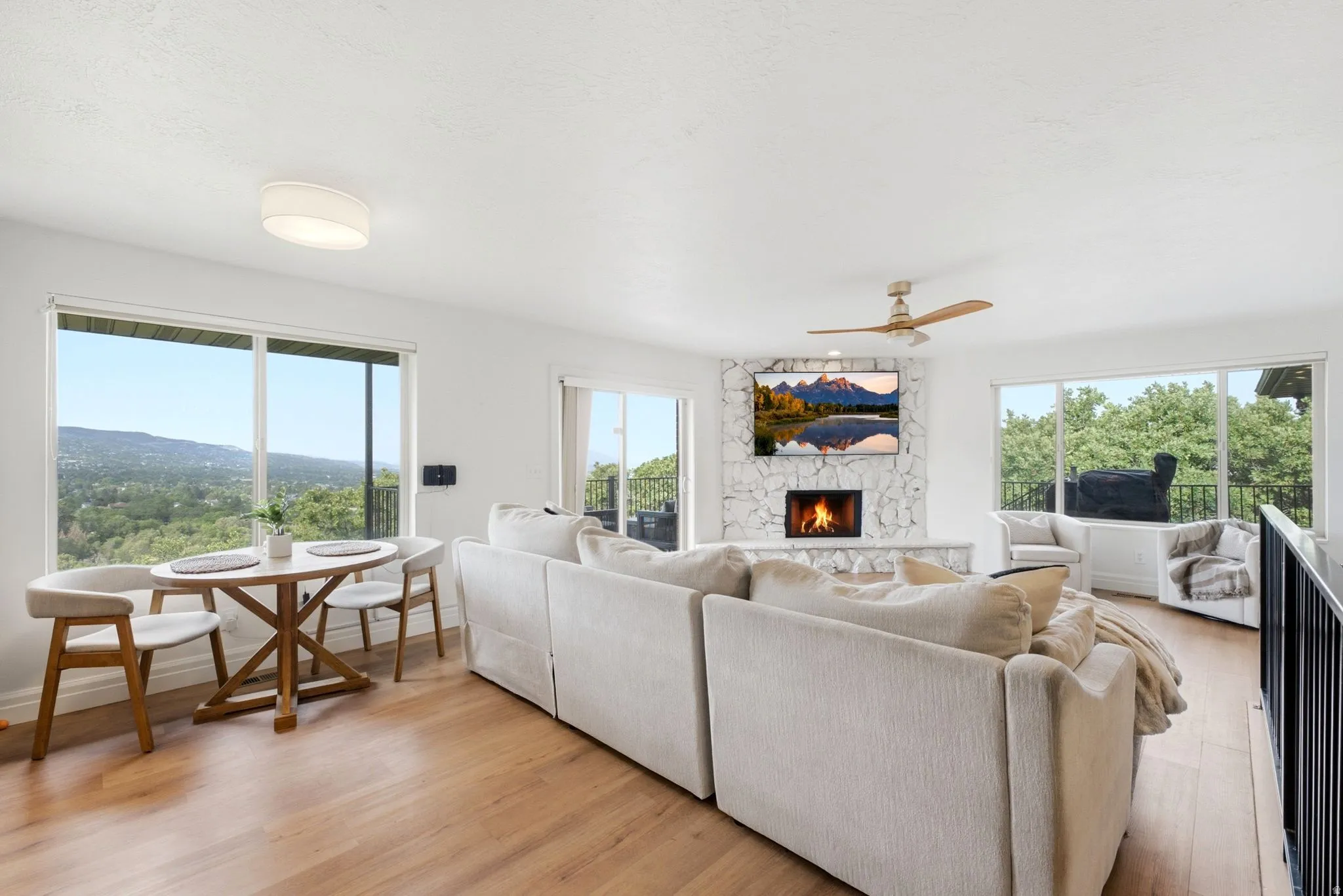 Living area featuring light wood-finish flooring and multiple large windows
