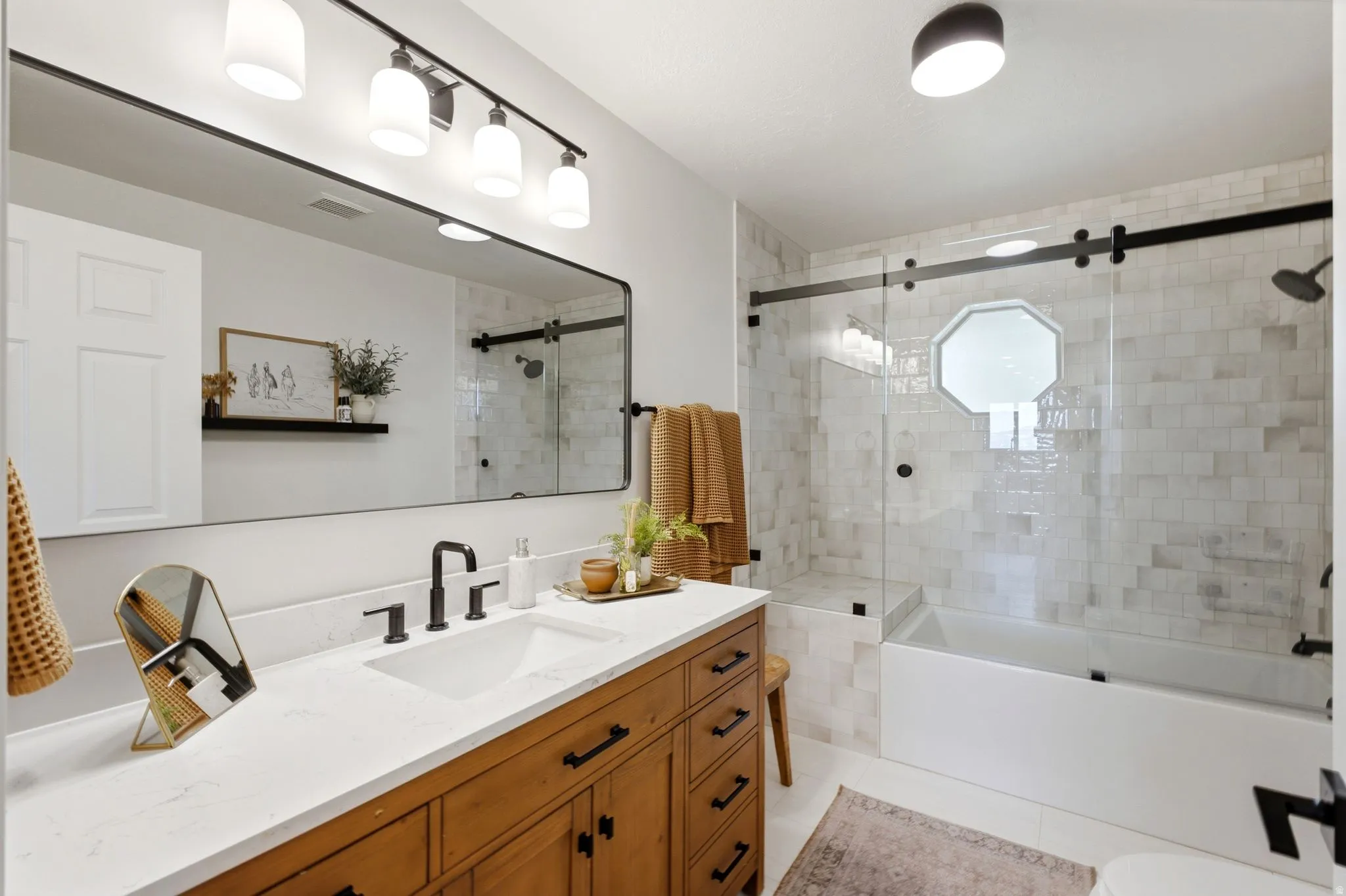 Bathroom featuring a wood-finish vanity with a white countertop and undermount sink