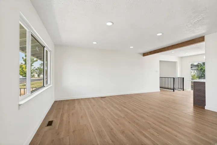 Spacious room featuring wood-finish flooring, recessed lighting, and a prominent window