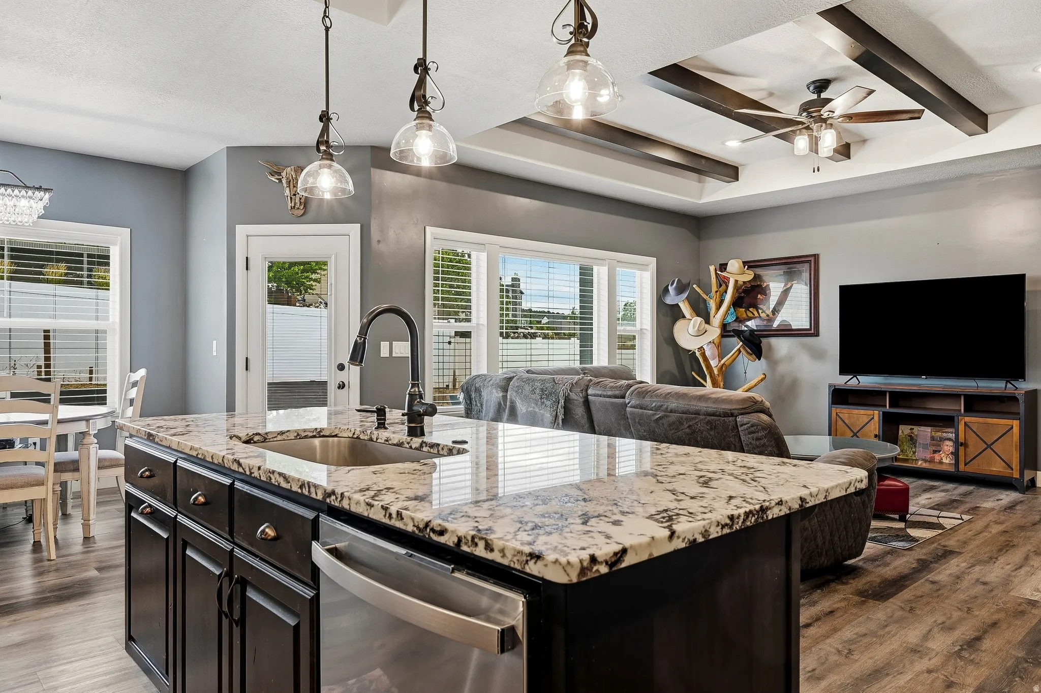 Kitchen island with granite countertop, undermount sink, and stainless steel dishwasher