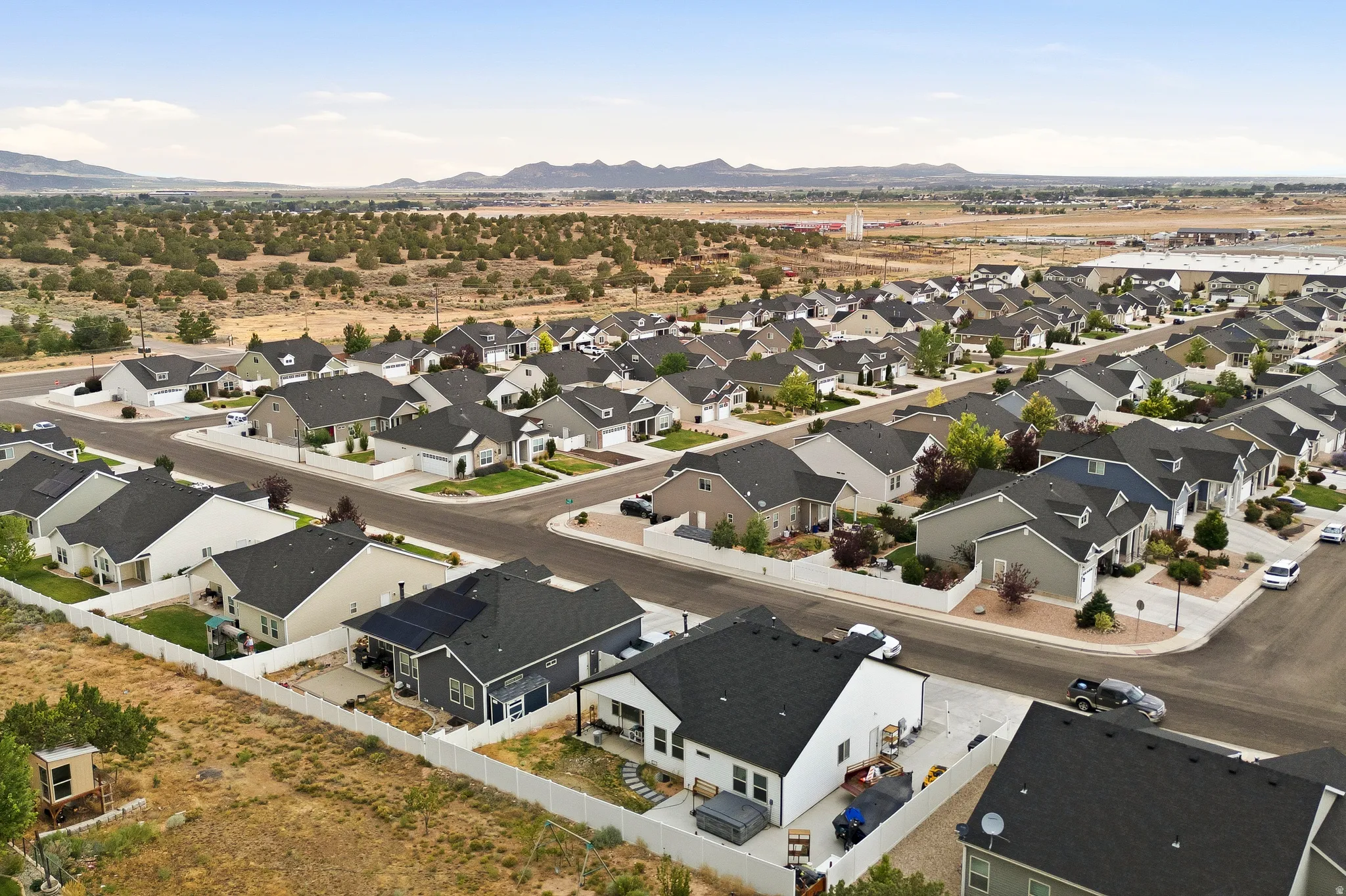 Expansive residential development featuring a collection of modern single-story homes with dark asphalt shingle roofs