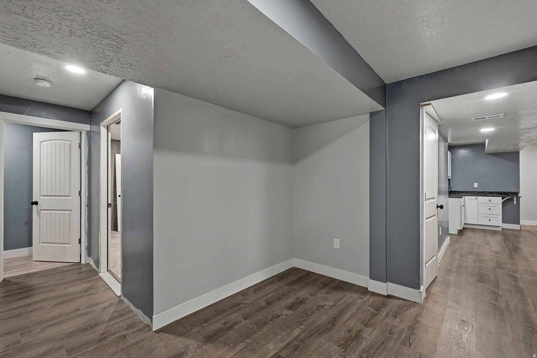 Interior hallway featuring wood-finish flooring, recessed lighting, and white baseboards