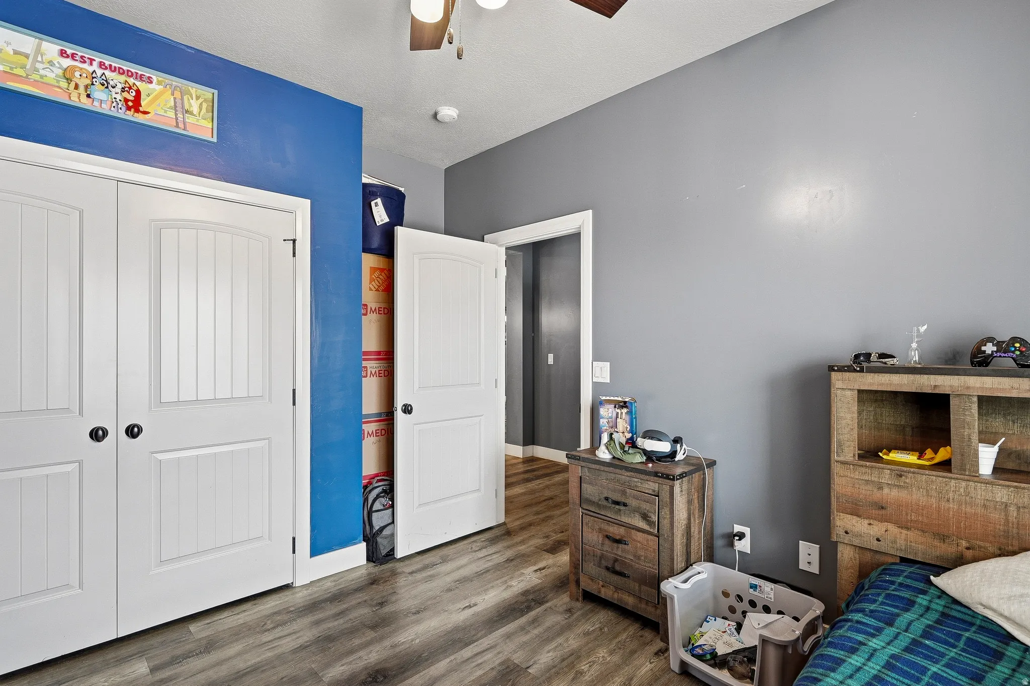 Room featuring wood-finish flooring and a ceiling fan with integrated lighting