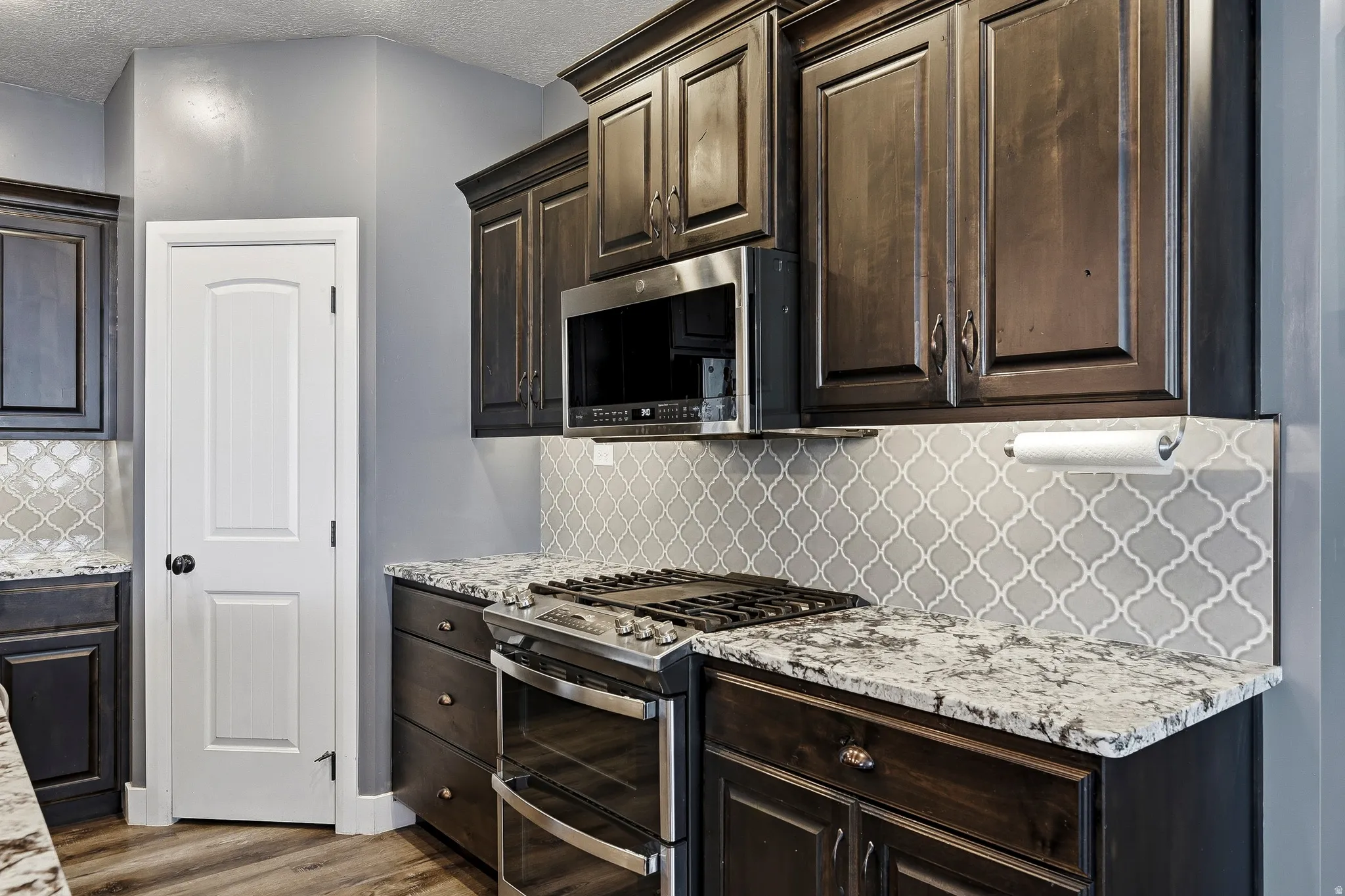 Kitchen featuring dark wood cabinetry and light-colored countertops