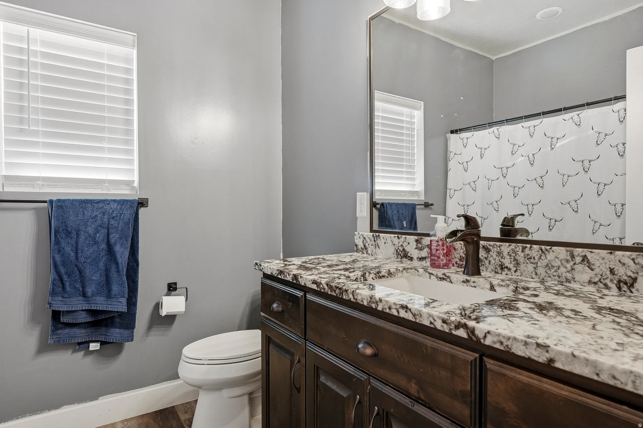 Vanity featuring a built-in sink, stone-finish countertop, and dark wood-finish cabinetry