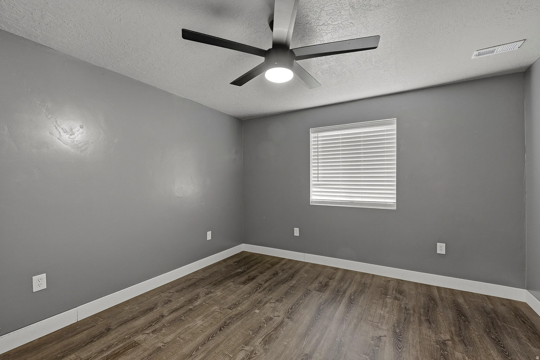Room featuring wood-finish flooring, a contemporary ceiling fan with integrated lighting, window blinds, and white baseboards