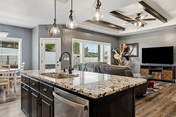 Kitchen island with granite countertop, undermount sink, and stainless steel dishwasher