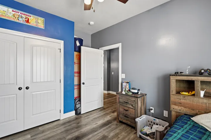 Room featuring wood-finish flooring and a ceiling fan with integrated lighting