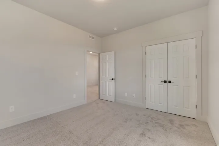 Neutral-toned walls complement the light gray carpet flooring