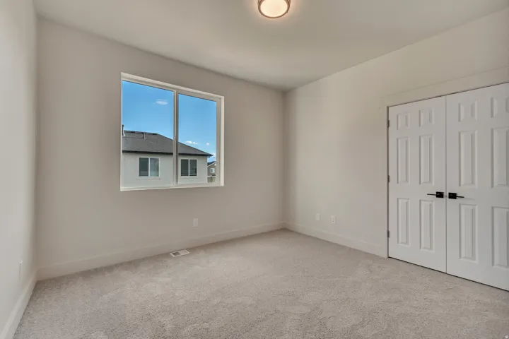 Spacious interior featuring neutral wall tones, light gray carpet, and white baseboards