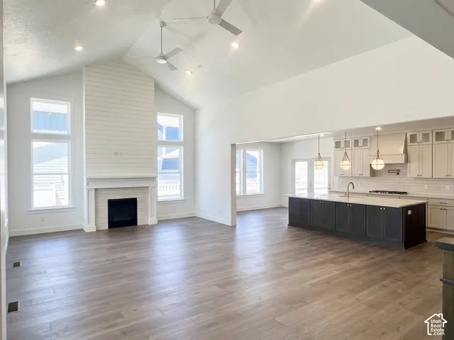 Vaulted great room featuring wood-finish flooring and a fireplace with a shiplap accent wall
