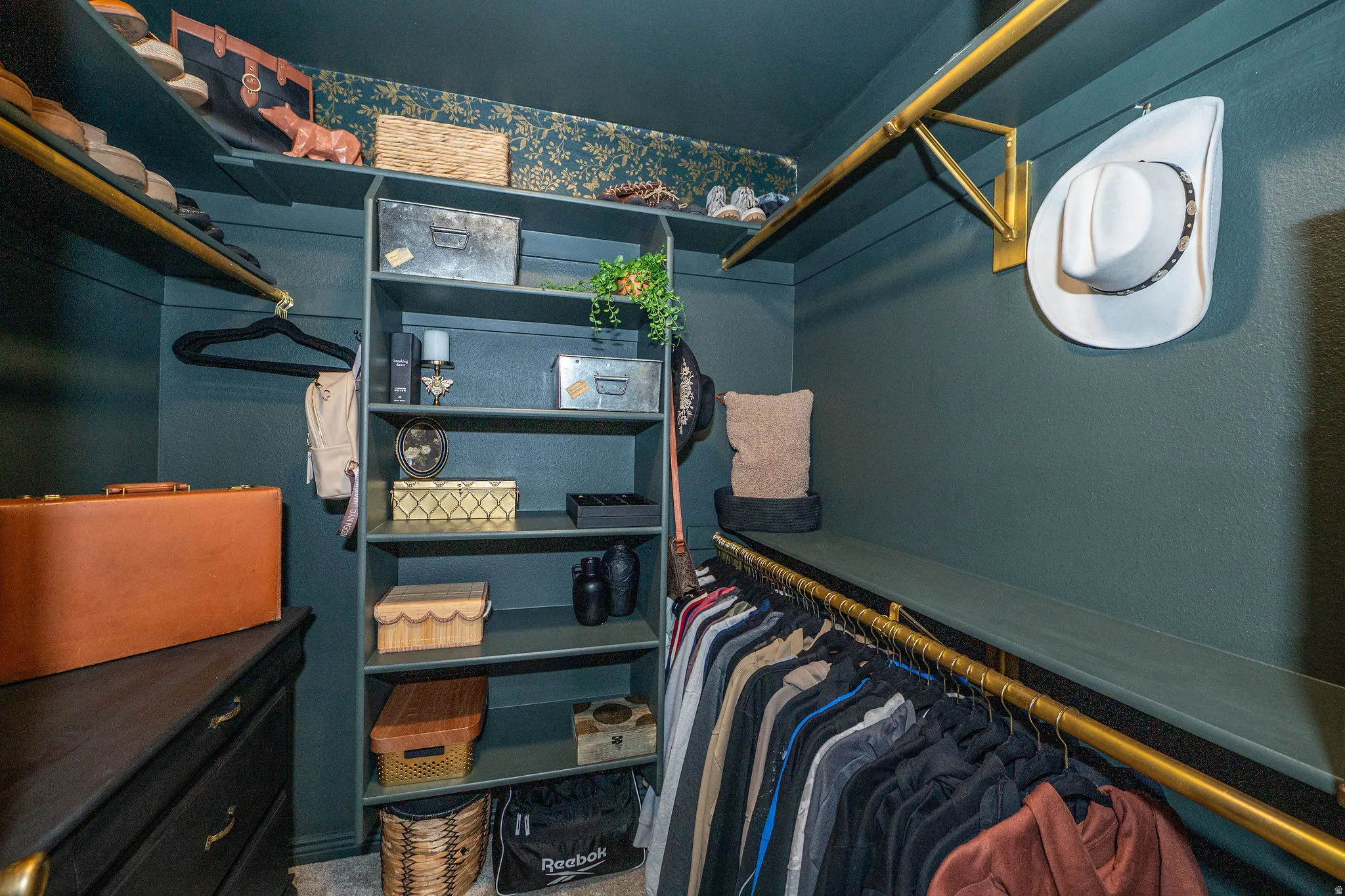 Custom closet system featuring built-in shelving, hanging rods, and a dresser