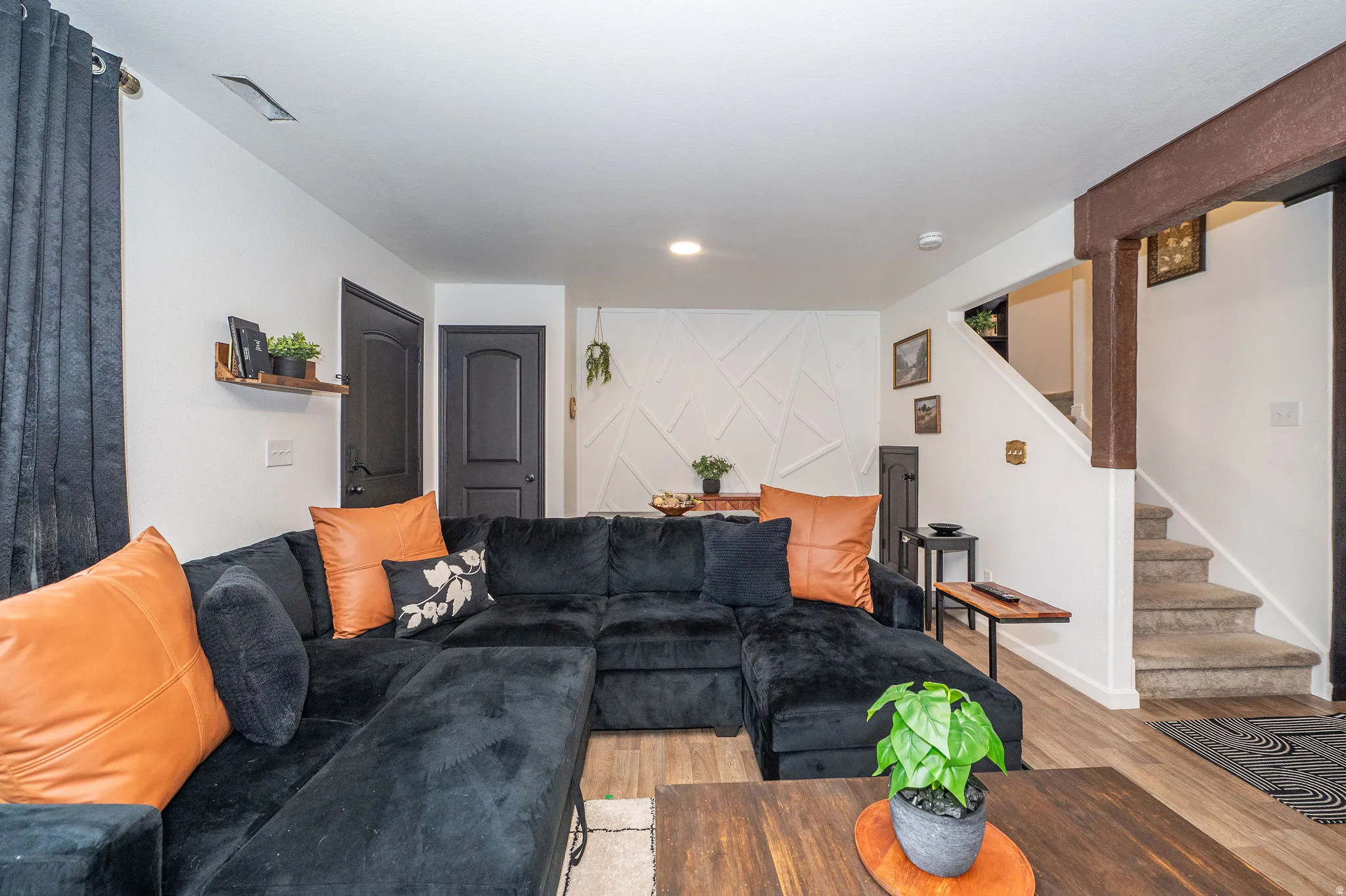 Living area featuring wood-finish flooring, white walls, and dark interior doors