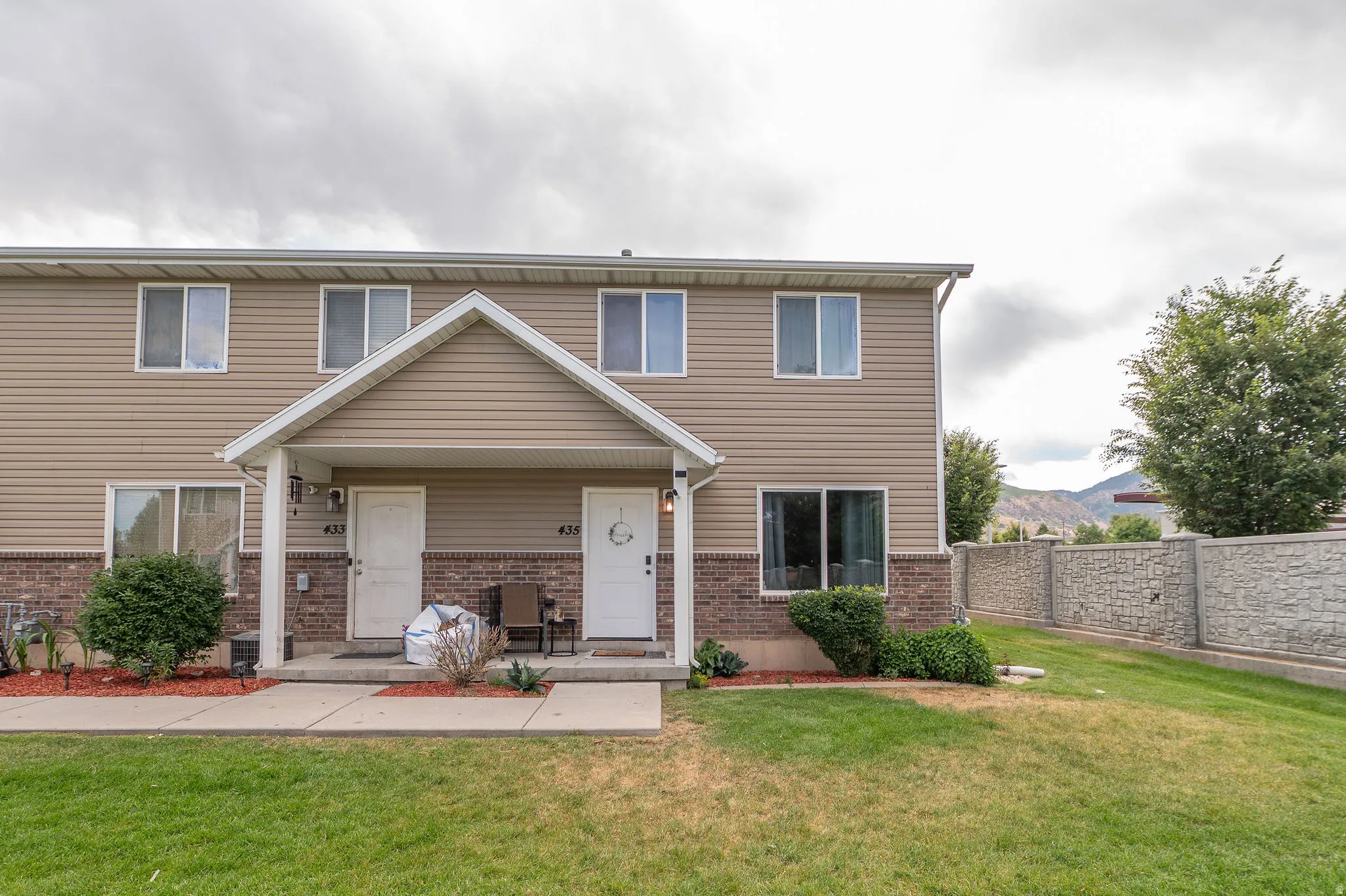 Two-story exterior with vinyl siding and brick facade