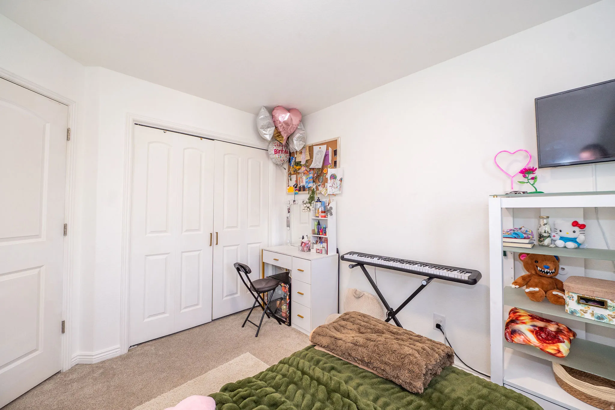 Neutral wall color, carpeted flooring, and a large bi-fold closet with panel doors