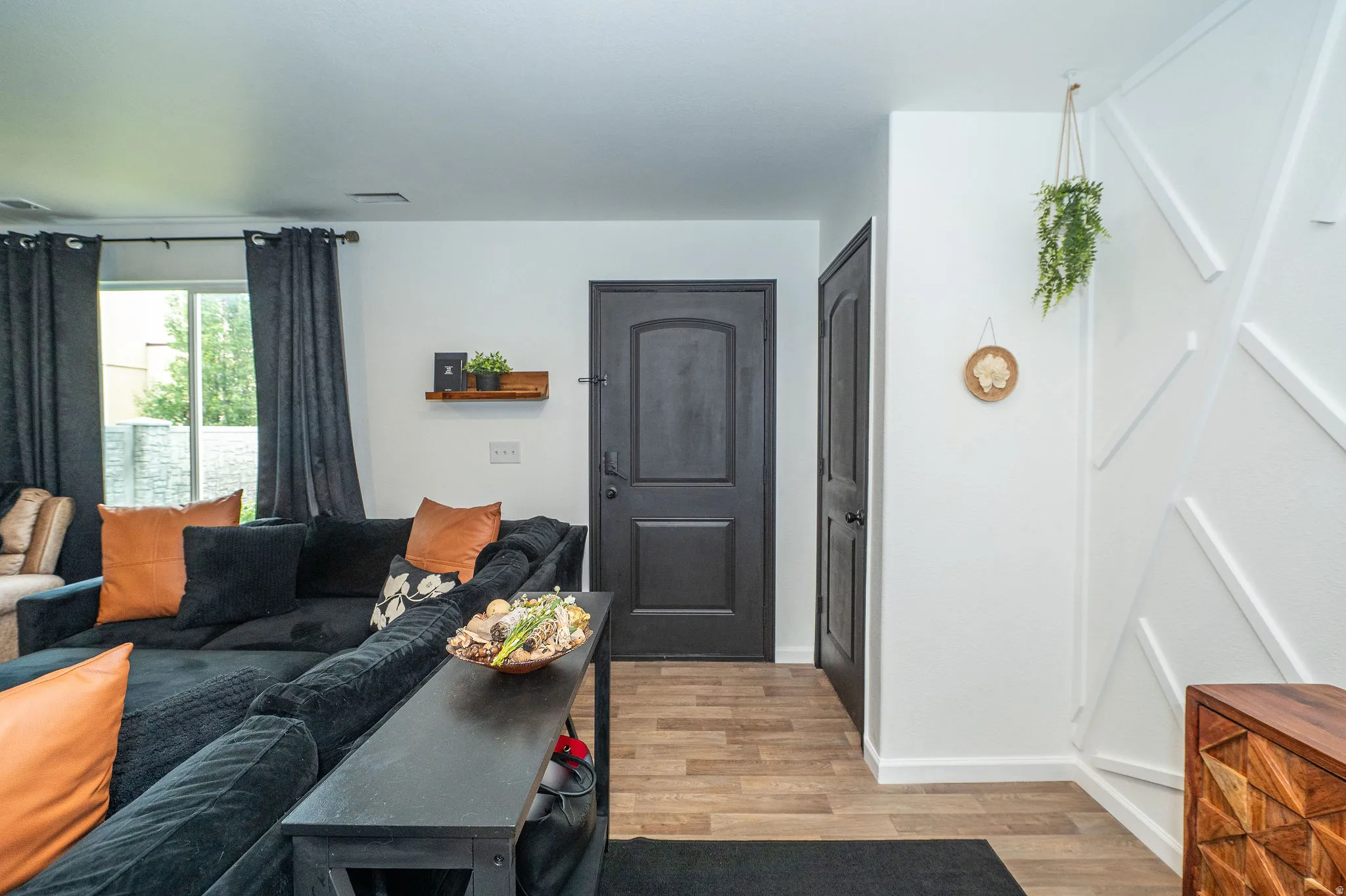 Interior space featuring wood-finish flooring, white walls, and a decorative geometric wall accent