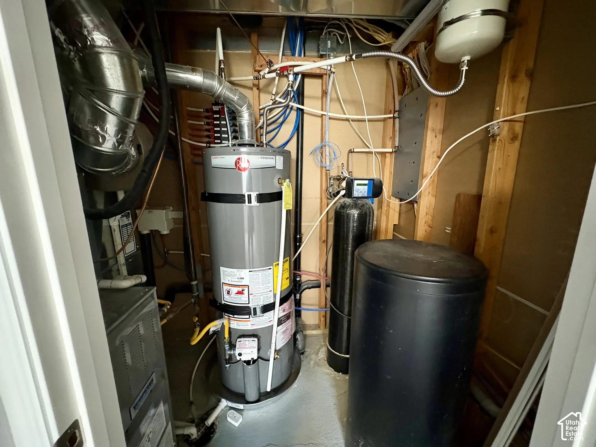 Utility area featuring a water heater, furnace, water softener system, and an expansion tank