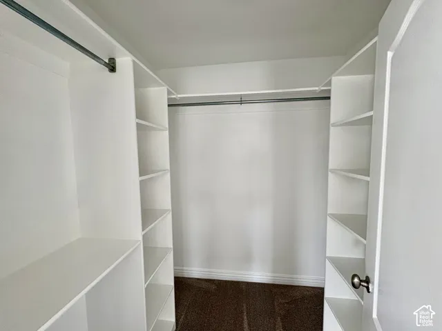 Master closet. Built-in closet organization system featuring white shelving and chrome hanging rods