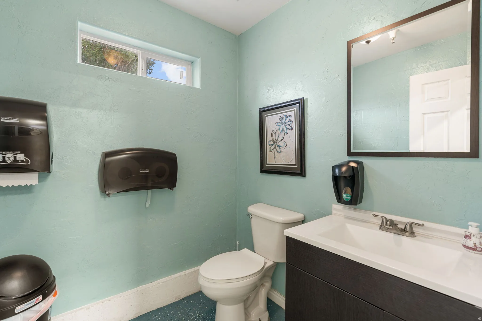 Vanity featuring a white basin sink with a chrome faucet, dark wood-finish cabinetry, and a framed mirror