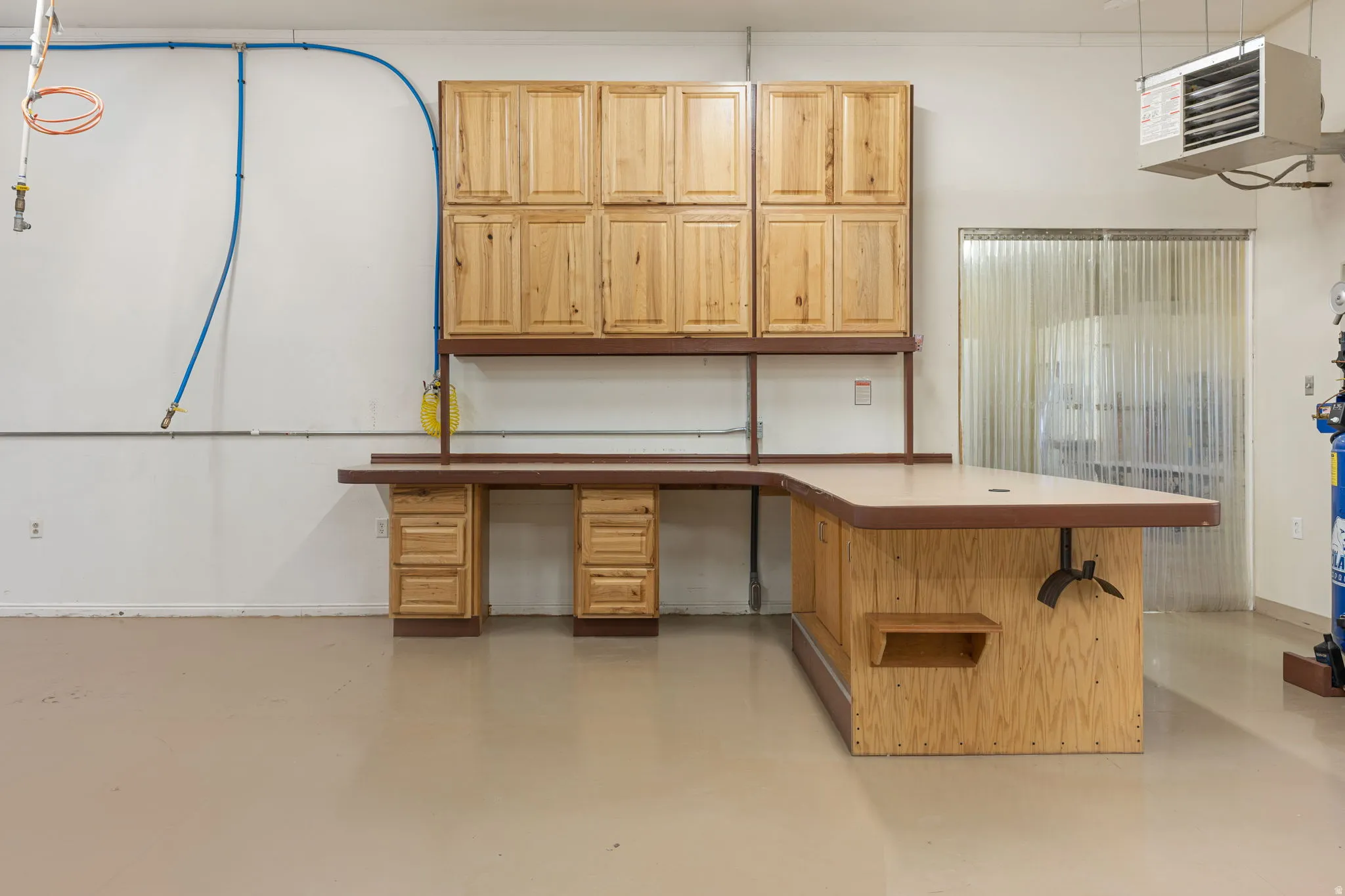 Integrated L-shaped workbench with built-in cabinetry and drawer storage