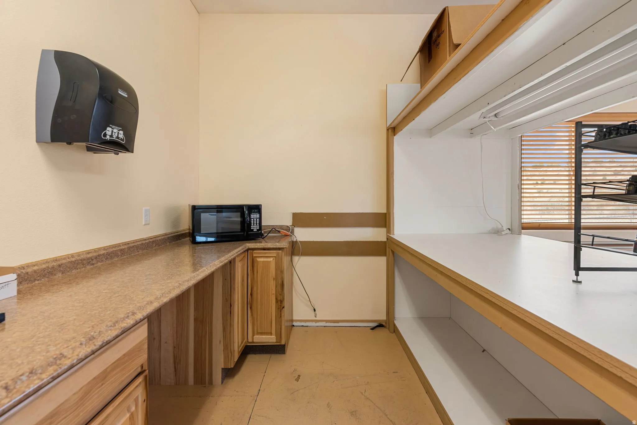 Utility room featuring extensive countertop space, wood-finish cabinetry, and built-in shelving