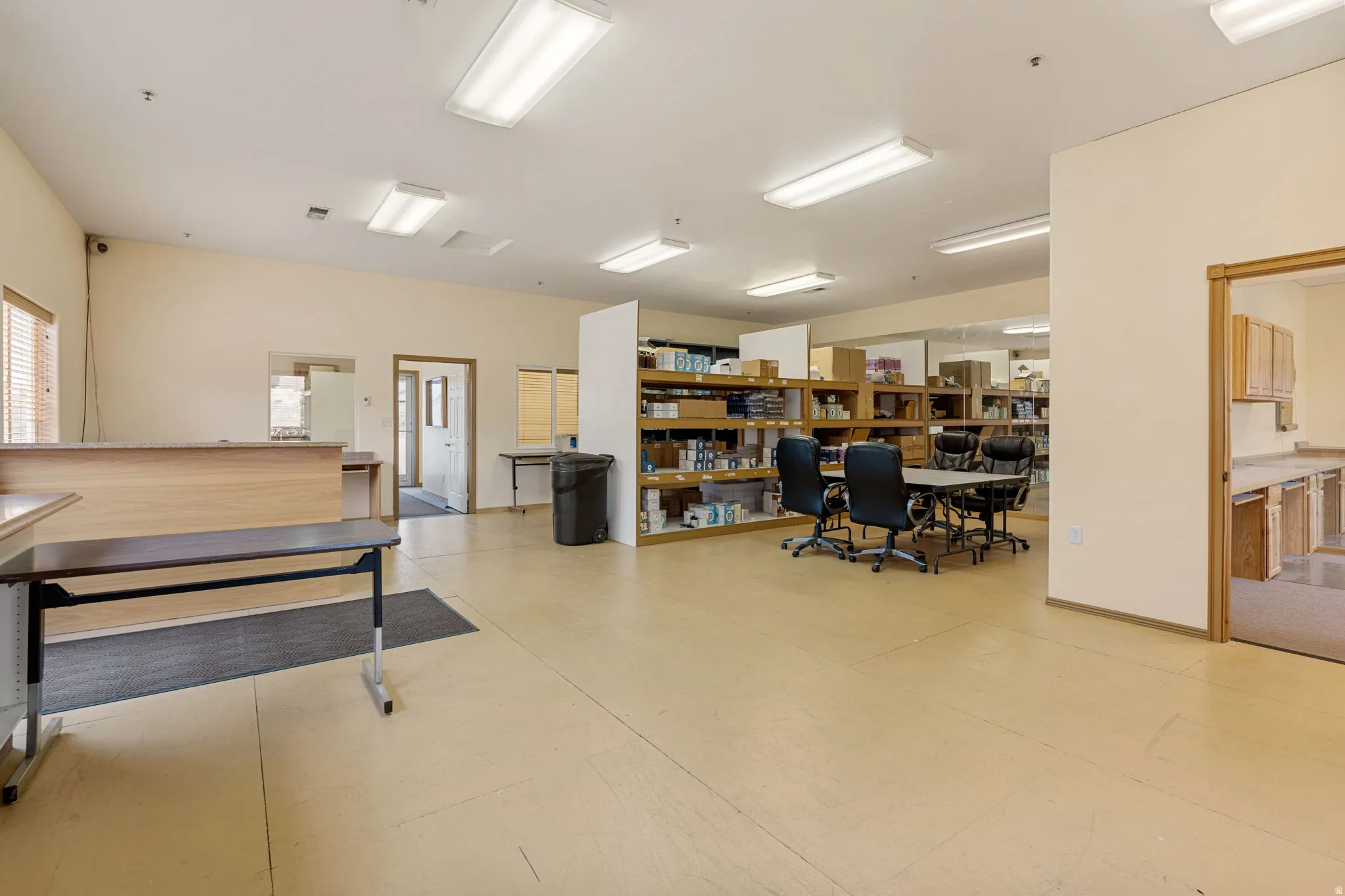 Expansive open-concept space featuring recessed lighting, a light-toned flooring, and multiple doorways leading to additional rooms