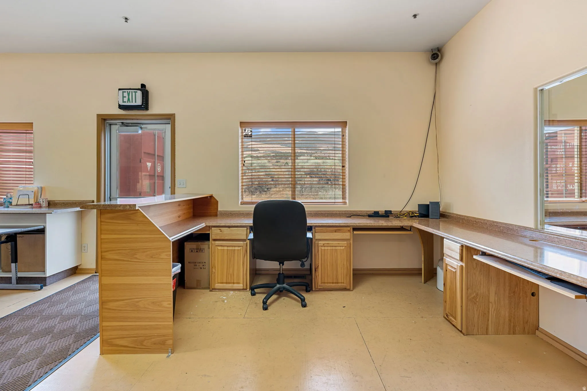 Workstation area featuring wood-finish cabinetry, built-in countertops, and window blinds