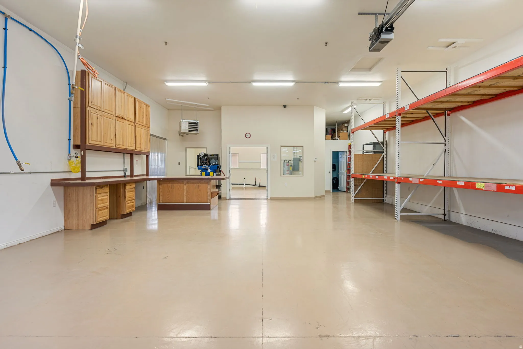 Spacious work area featuring light-toned flooring and overhead fluorescent lighting