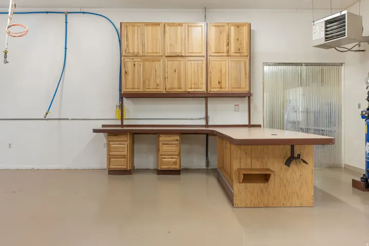 Integrated L-shaped workbench with built-in cabinetry and drawer storage