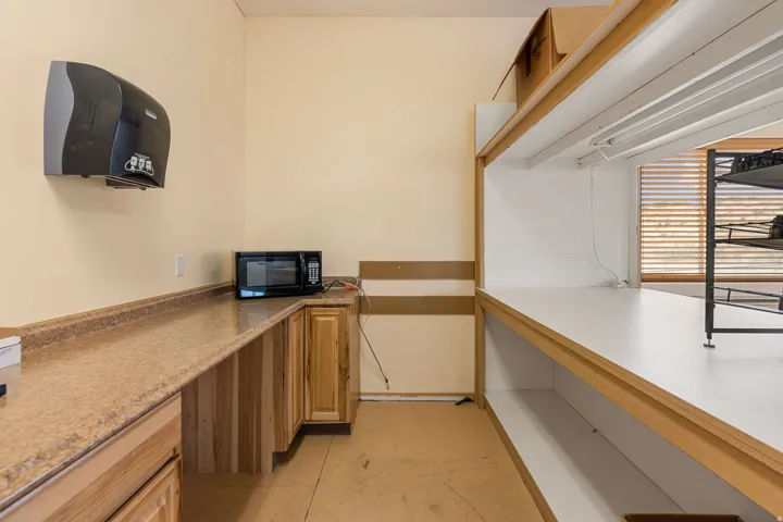 Utility room featuring extensive countertop space, wood-finish cabinetry, and built-in shelving