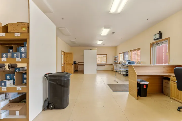 Spacious open-plan interior featuring light-toned flooring, recessed lighting, and a wood-finish reception counter