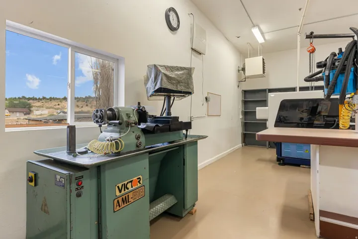 Spacious workroom featuring a large window, light-colored flooring, and built-in shelving
