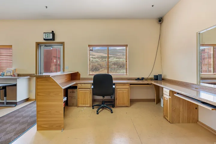 Workstation area featuring wood-finish cabinetry, built-in countertops, and window blinds