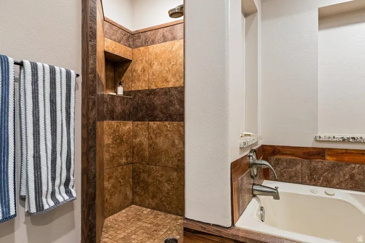Shower and soaking tub with mixed tile and wood paneling accents