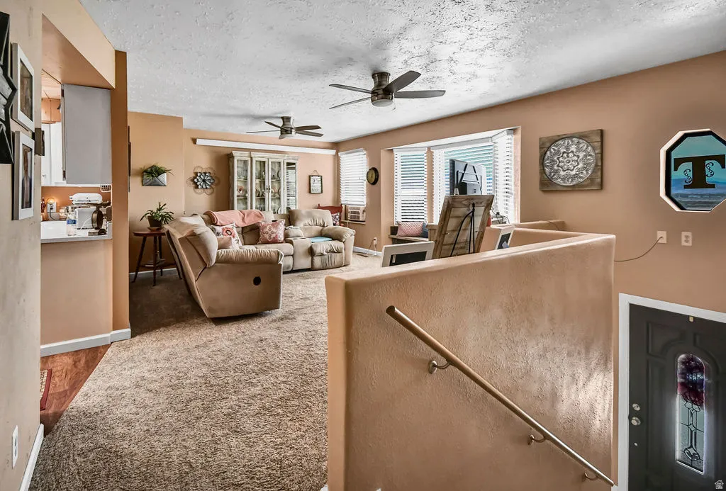 Open-concept living space featuring carpet flooring and neutral wall tones