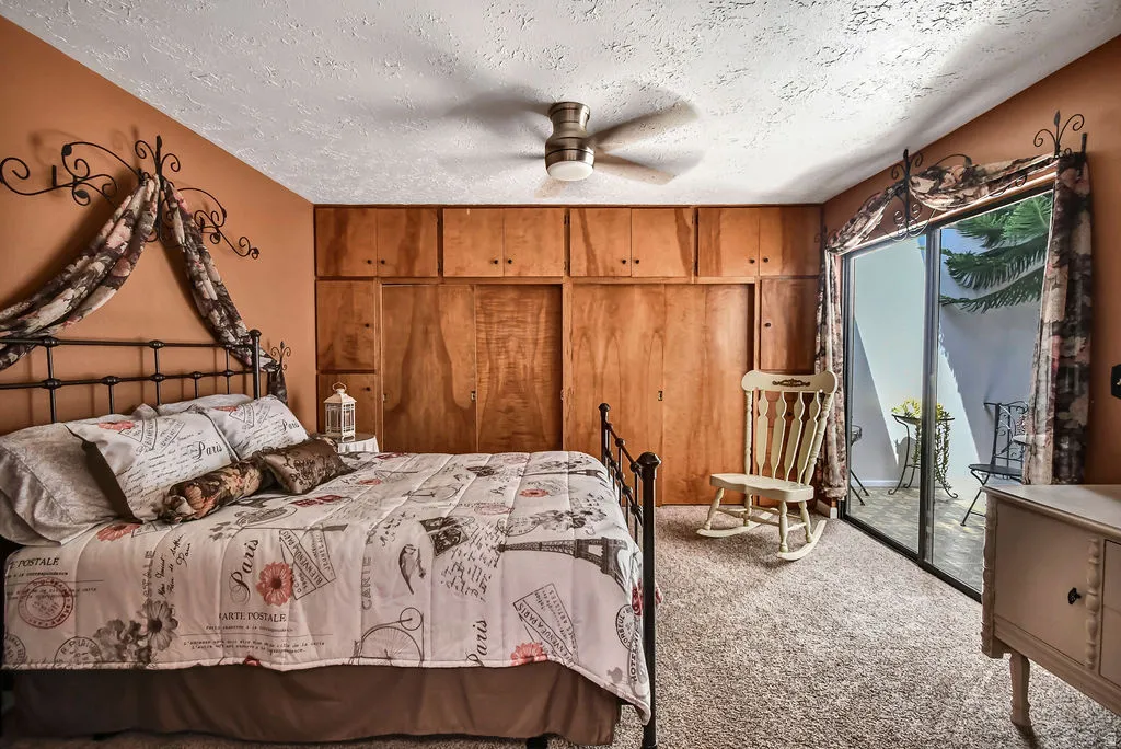 Bedroom featuring wood-finish built-in cabinetry, sliding glass doors, and carpet flooring