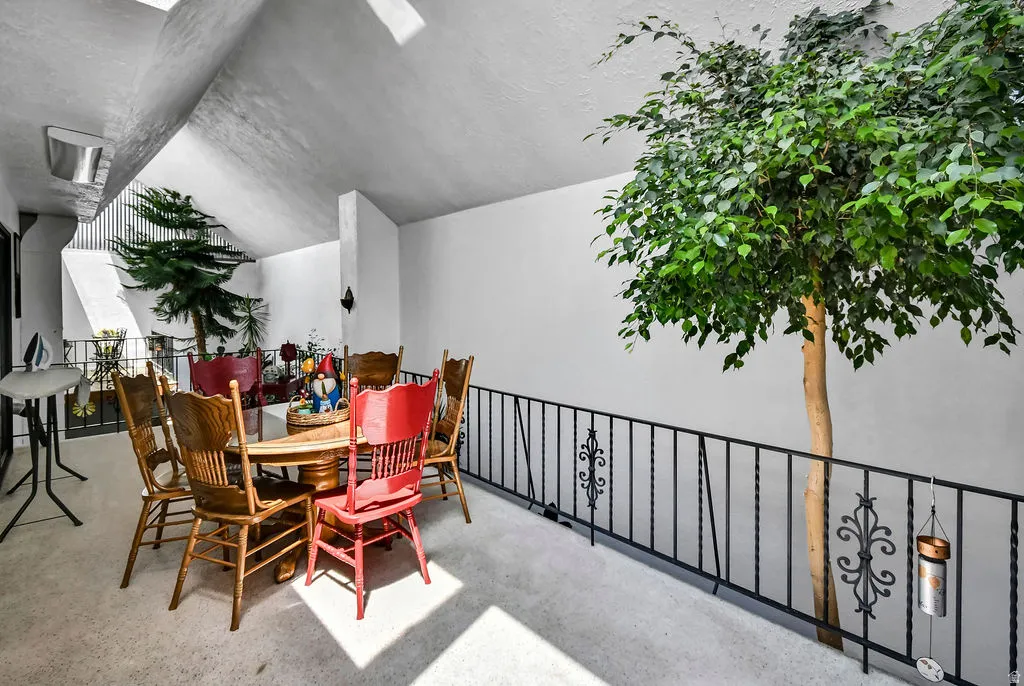 Upper-level landing featuring a decorative wrought iron railing, white walls, and a textured white ceiling