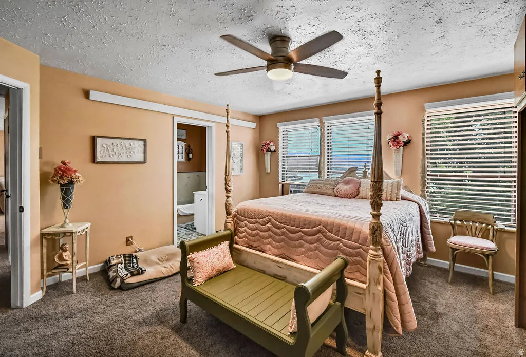 Carpeted room featuring multiple windows with blinds, a ceiling fan with integrated lighting, and a doorway opening to an additional space
