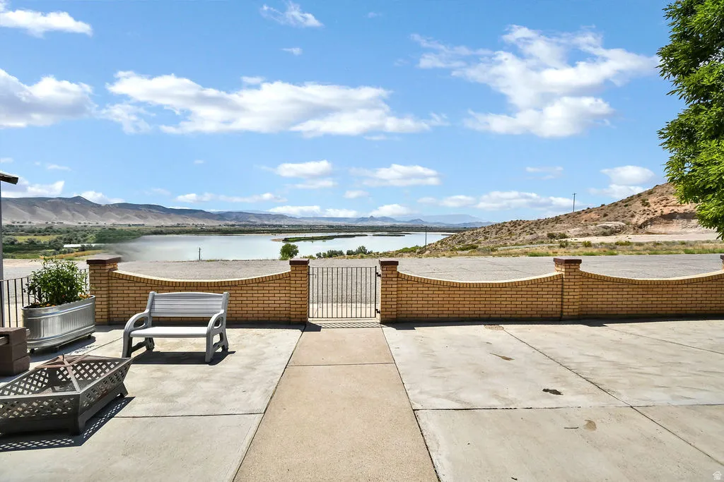 Expansive outdoor patio featuring a concrete surface, a decorative brick wall, and a metal gate