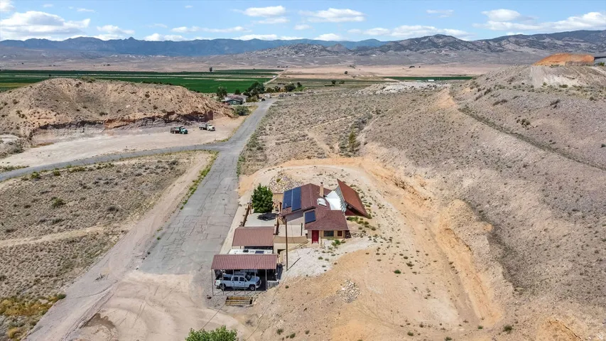 Property situated in a desert landscape with mountain ranges and cultivated fields in the background