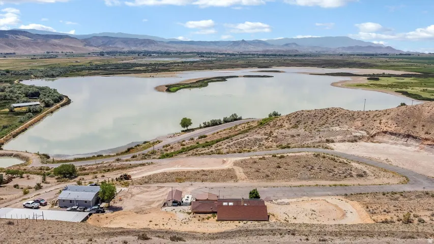 Expansive landscape featuring a large body of water surrounded by natural terrain and distant mountains