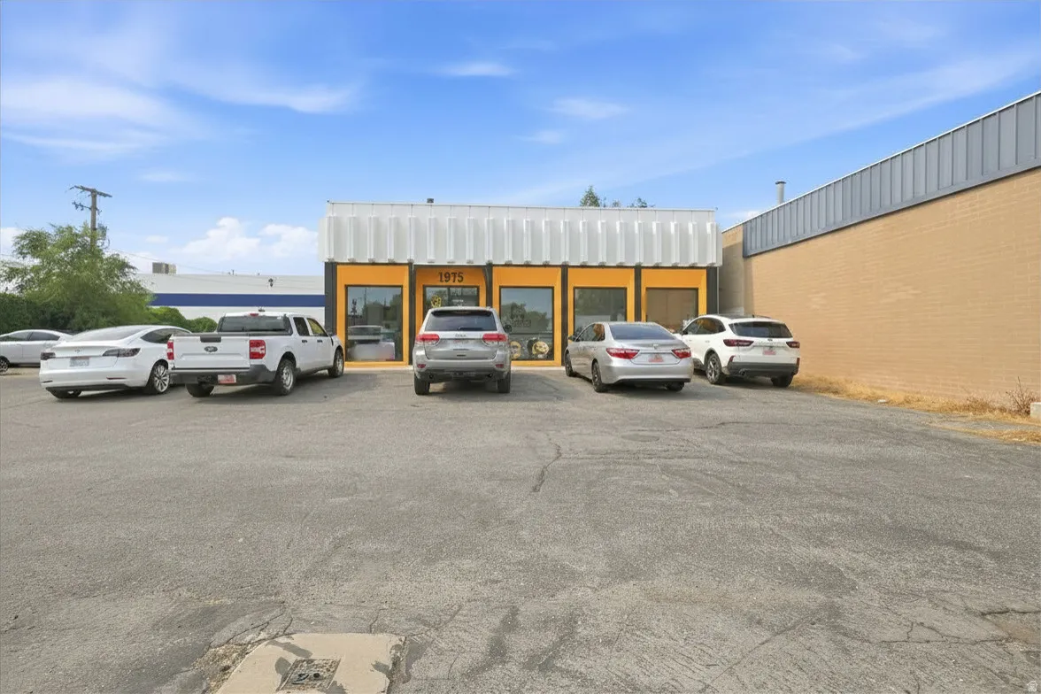 Commercial building with a prominent yellow storefront and large window displays