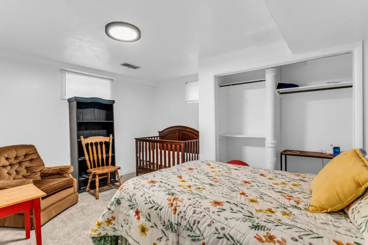 Carpeted room featuring a ceiling-mounted light fixture, white walls, and a window with blinds